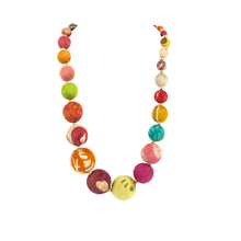 Ladda upp bild till galleriet Unikt halsband tillverkat av tygkulor av olika storlekar i återvunnet material. Detaljer och knäppe av mässingsfärgad metall. Alla halsbanden är handgjorda i ett indiskt kvinnoprojekt och ser inte exakt likadana ut. Längd 67 cm (hela vägen runt).