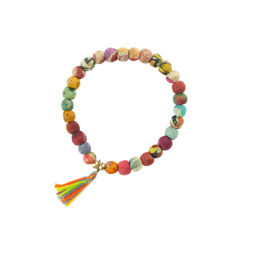 Ladda bild 1 i i galleriläge. Armband tillverkat av tygkulor av återvunnet material. Armbandet är trätt på gummiband för att passa alla, och dekorerat med en tofs i olika färger. Armbanden tillverkas av indiska kvinnor i deras hemmiljö för att förbättra deras levnadsvillkor.